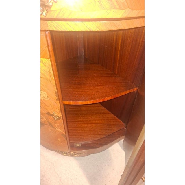 Corner cabinet in marquetry with a marble top, featuring two doors and a drawer. 20th-century manufacture. It has an...