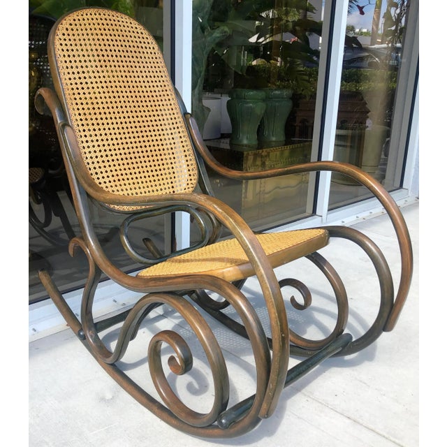 Timeless rocking chair in the style of Thonet. Green stained with back and seat in caning. Caning was replaced and is in...