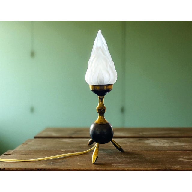 This tripod table lamp is a perfect example of the a950s-60s Space Age design. Made of brass and topped with a flame-...