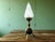 This tripod table lamp is a perfect example of the a950s-60s Space Age design. Made of brass and topped with a flame-...