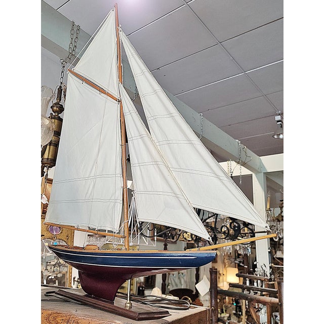 The beauty and grace of a classic gaff rigged sloop is admired even by landlubbers and this vintage wooden model on stand...