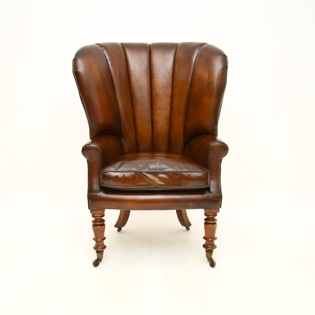 An outstanding antique Victorian leather barrel back wing armchair. This was made in England, it dates from around the...