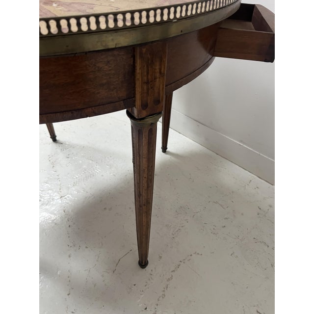 Louis XVI style bouillotte table in veneered wood It rests on four fluted legs The top is a breccia marble slab surrounded...