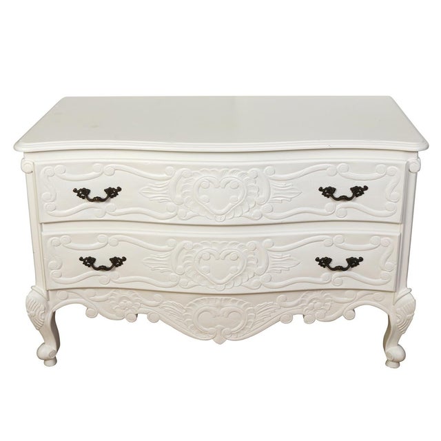 A painted French Rococo style bombe chest. Finished in a matte white, this two drawer commode showcases hand carved...