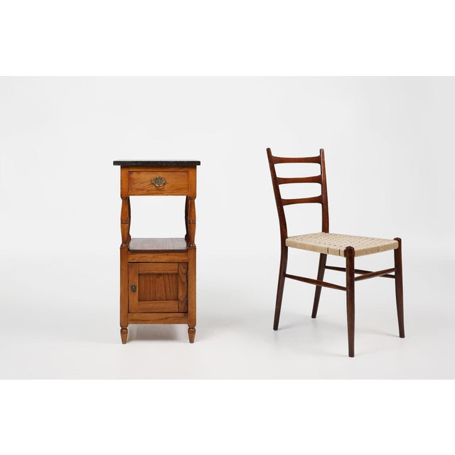 A refined French Art Deco night stand from around 1920, combining warm polished wood with a striking blue stone top. The...