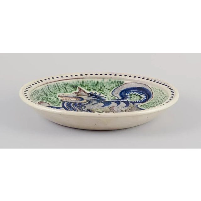 Svend p. Jørgensen, danish ceramicist. Unique large ceramic bowl with a stylized creature. Hand-glazed in blue, green, and...