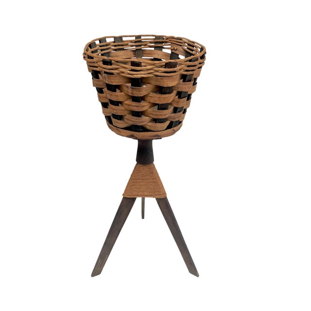 A striking pair of vintage woven basket planters elevated on sculptural tripod stands, blending organic texture with mid-...