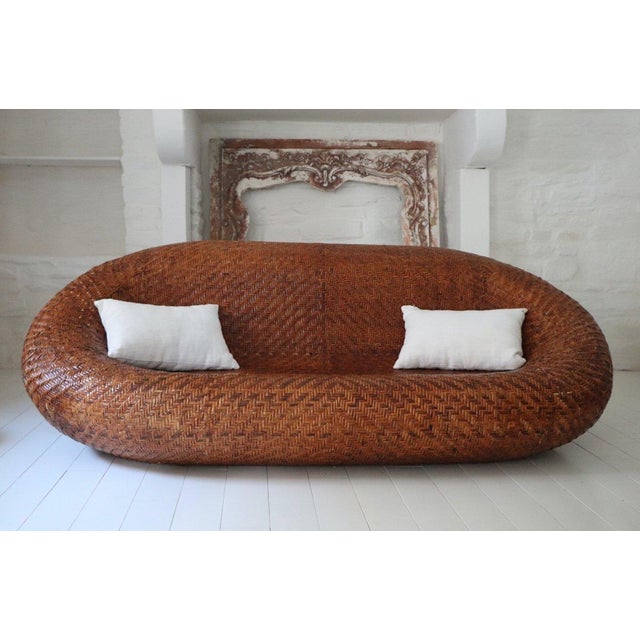 Large, organically shaped woven wicker sofa dating from the 1970s. Its design is distinguished by a deep seat and...
