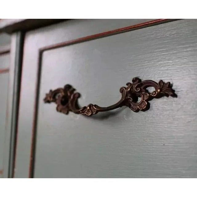 Sets of three vintage French Provincial-style bail pull, featuring a cast metal construction with an antiqued finish,...