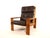 This Bonanza armchair from the 60s comes in the rare version as a high-backed chair and in dark brown leather with an oak...
