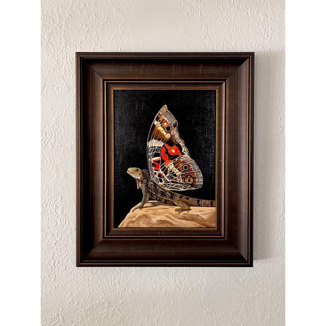 This artwork presents a striking fusion of a lizard and a butterfly, showcasing a meticulously rendered iguana with an...