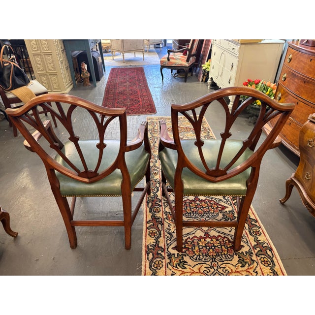 This is a set of 2 vintage shield-back mahogany dining chairs. They are Hepplewhite style. They have a leather seats ....