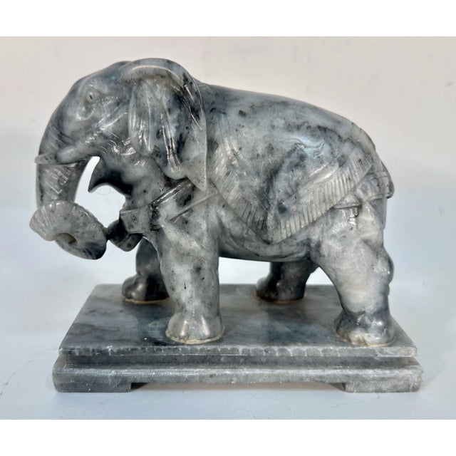 Carved soapstone elephant standing 5" tall with a 3" x 6" base. There is a partial sticker on the bottom that only reads...