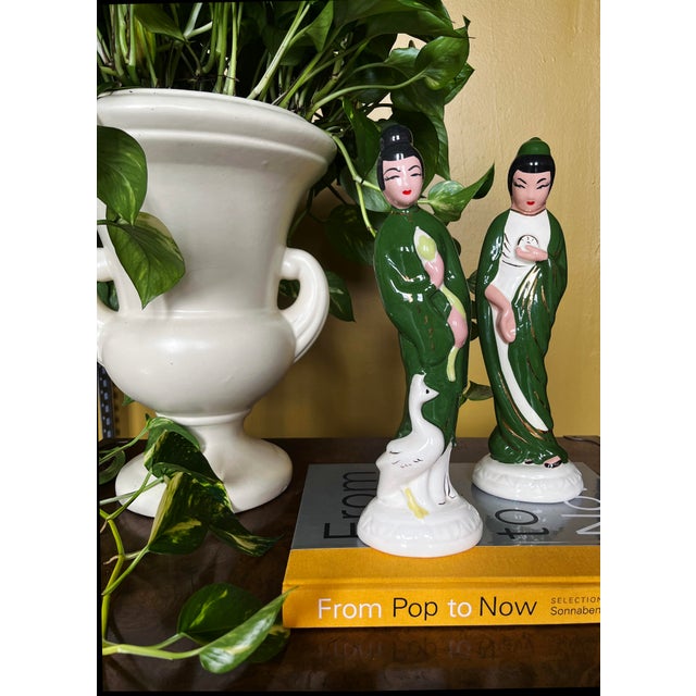 Pair of Hollywood Regency, Mid-Century ceramic figurines, hand-painted in green, white, pink, and black with red accents....