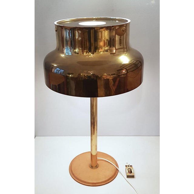 The large model of the Bumling table lamp with a leather-covered base plate. High quality workmanship. The matt leather...