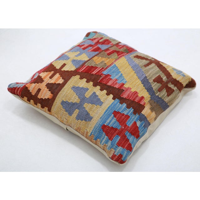 A one-of-a-kind handwoven Afghan wool kilim accent pillow featuring bold geometric patchwork blocks. Cut and sewn by hand...