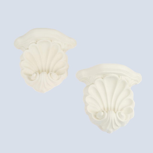 Charming pair of vintage wall shelves cast in white plaster with an elegant shell scroll corbel form. Each piece mounts...