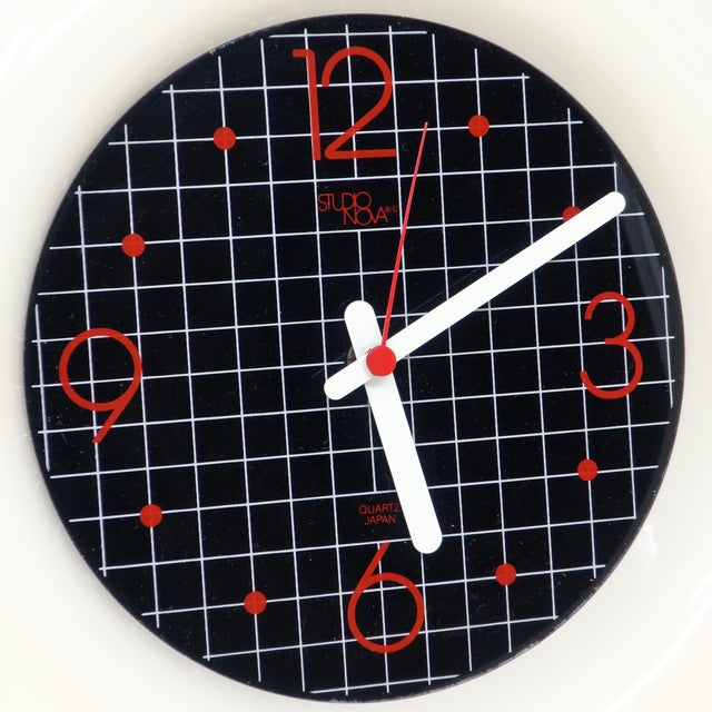 A very cool and unique 1980s wall clock by Studio Nova Japan with a cartoonish white border, black face with white grid...