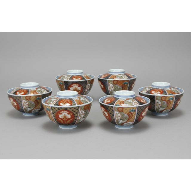 Antique Japanese Imari porcelain bowls with lids, set of 6. Each with alternating panels showing a hand painted floral,...