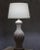 A sculptural Spanish Mid-Century table lamp from the 1950s, featuring a gracefully formed white ceramic body with a richly...