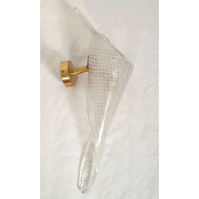 Pair of clear handmade Murano glass sconces, attributed to Seguso, Italy 1970s. The Mid-Century sconces have brass mounts...