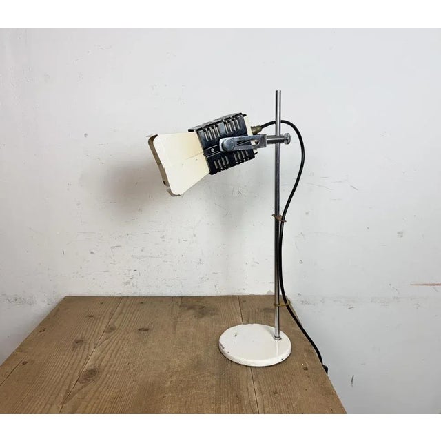 This height adjustable table lamp was produced in former Czechoslovakis during the 1970s. It features a metal lampshade, a...