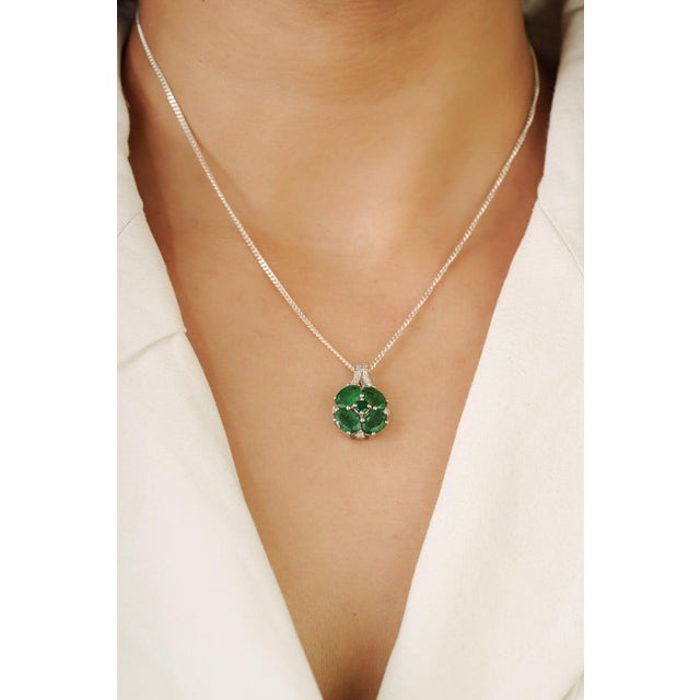 This beautiful emerald pendant features a floral-inspired arrangement of natural emeralds accented by sparkling diamonds...
