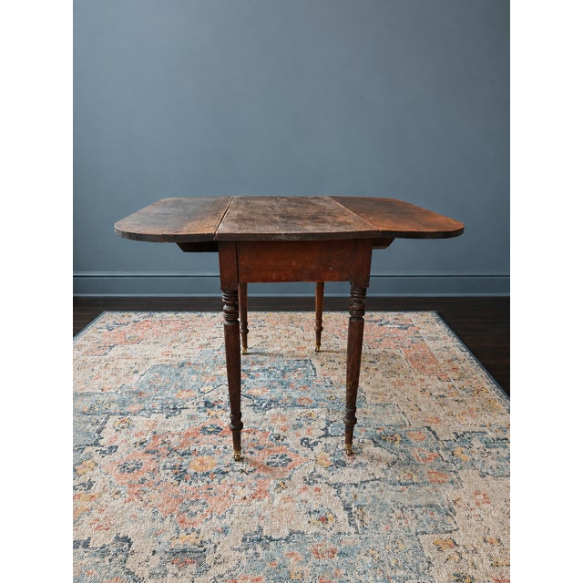 Well-loved antique drop-leaf table that would make an easy addition to a variety of spaces. Top has a weathered patina...