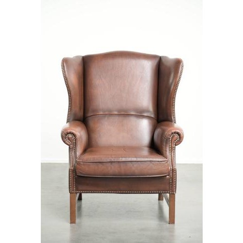 This comfortable English-style wingback chair is made of cowhide leather and has a timeless look. It features a removable...