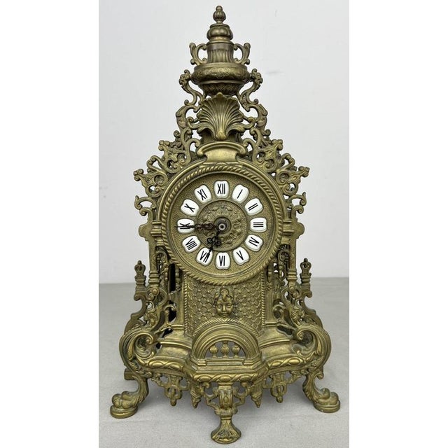 An elaborate Vintage French clock with an impressive architectural form, richly decorated with scrolling openwork, shell...