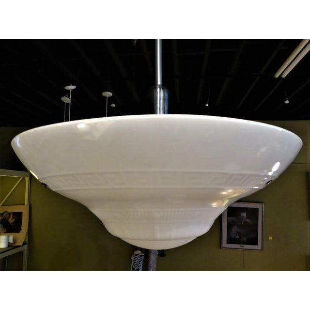 Sleek period Streamline Moderne light featuring a wide conical thick milk glass bowl with concentric ribs in the glass...