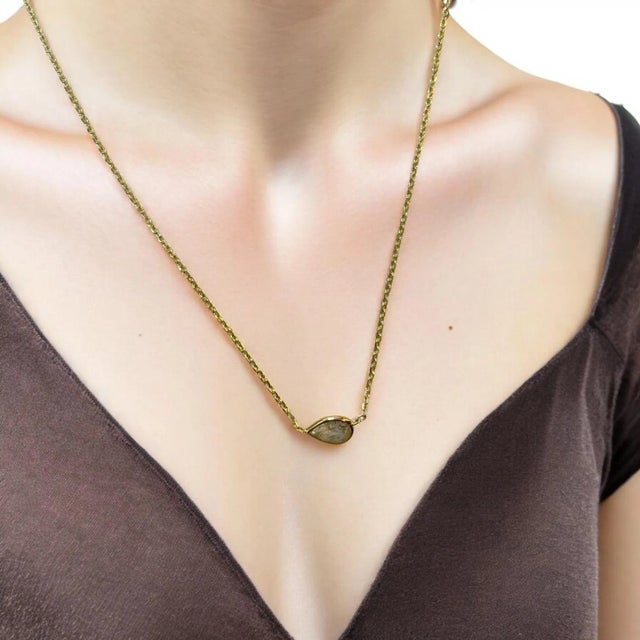 Embrace the beauty of this graceful creation, showcasing a 0.76ct pear-shaped natural diamond in a sleek bezel setting....