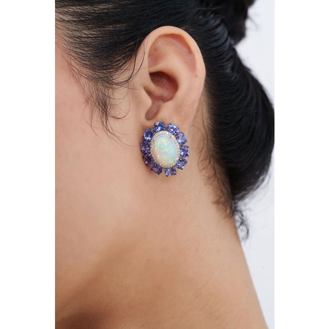 These target cluster stud earrings feature 14.24 carats of oval opals and blue sapphires, set in 18k white gold. The...