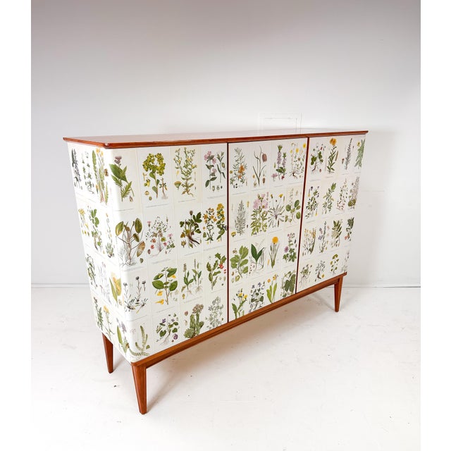 1950’s Swedish cabinet later papered with illustrations by C.A. Lindman book Nordens Flora. Cabinet consists of three...