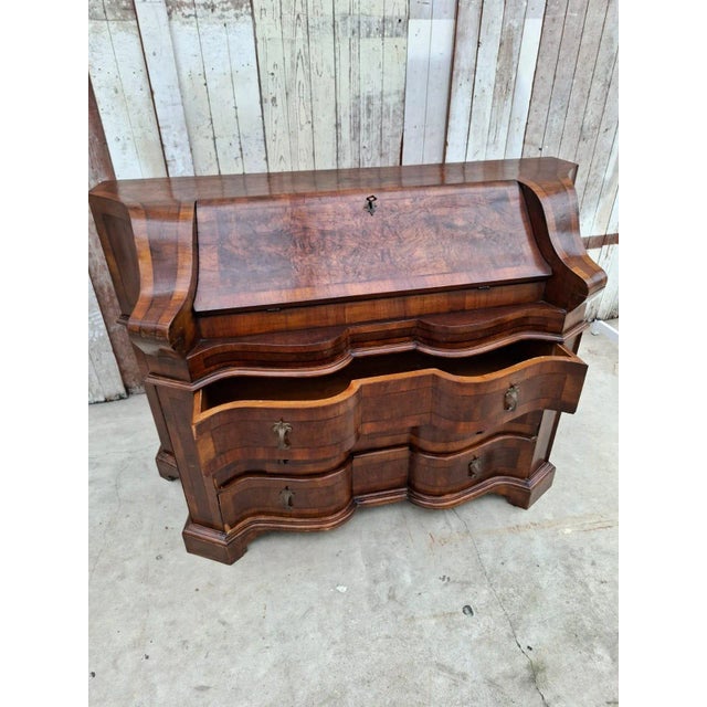 Decorative antique secretary desk in the Baroque Revival/Rococo style, featuring beautifully curved drawer fronts and warm...