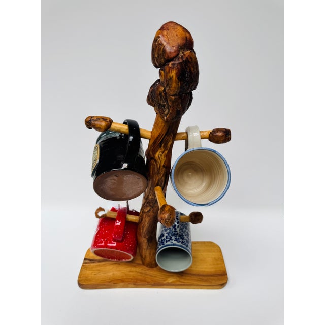 Handcrafted solid wood mug tree with a beautifully figured natural wood base and an unusual burl-like crown. The flowing...