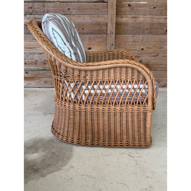 A beautifully crafted coastal rattan lounge chair and matching ottoman by Henry Link, known for their exceptional...