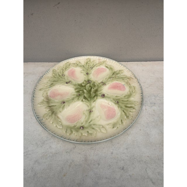 French Majolica oyster plate signed Hippolyte Boulenger Choisy-le-Roi. The six pink wells are surrounded by green seaweeds.