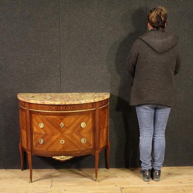 A half-moon dresser, early 20th-century France. A Louis XVI-style furniture finely inlaid with walnut, mahogany, maple,...