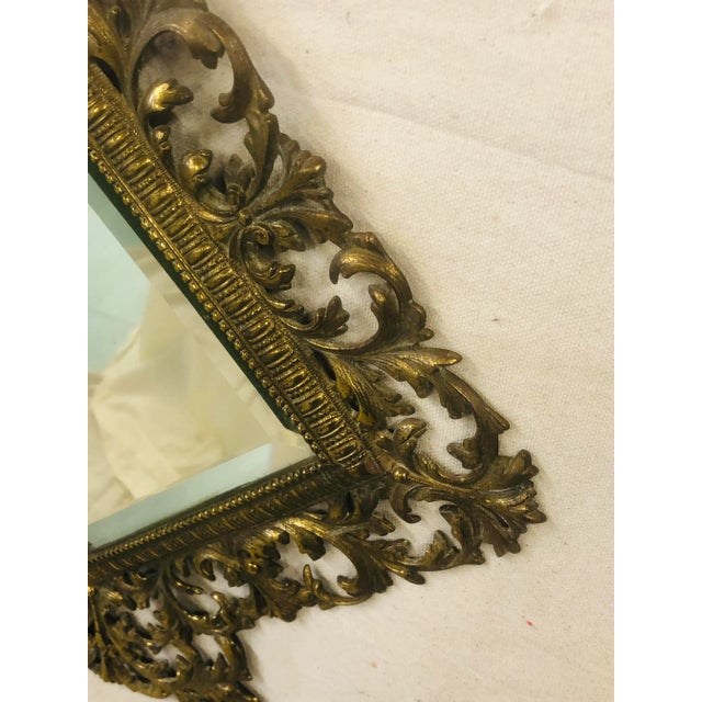 Nice brass mirror framed in leafy scrolls would be a great addition to any wall. Beveled mirror has haze but good reflection.
