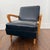 Authentic 1960s lounge chair with black leather upholstery and solid oak arms and legs. Low, relaxed profile with classic...