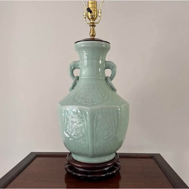This lovely 20th century Asian celadon table lamp features an octagonal shaped vase body with two elephant handles with...