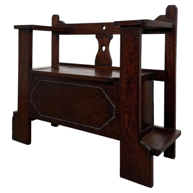 A charming early 20th-century English Edwardian hall seat, finely crafted from oak and combining comfortable occasional...