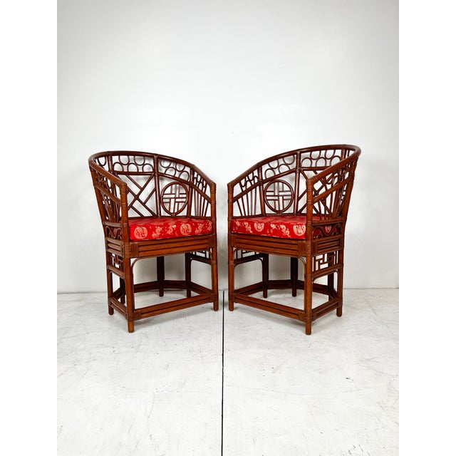 Vintage pair of 70's Chinese chippendale Brighton style rattan chairs. Horse shoe back rattan arm chairs with removable...