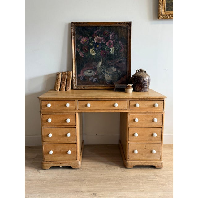 A classic English pine pedestal desk with a warm, honeyed tone and a softly worn surface that highlights its age and use....