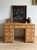A classic English pine pedestal desk with a warm, honeyed tone and a softly worn surface that highlights its age and use....