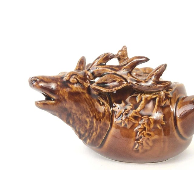 Crafted in the Showa Era, this vintage teapot and cup set features a charming and complex 3-D deer and maple leaf design,...