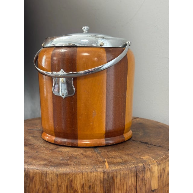 A charming vintage English biscuit barrel featuring a beautifully crafted two-toned wood exterior that creates a subtle...