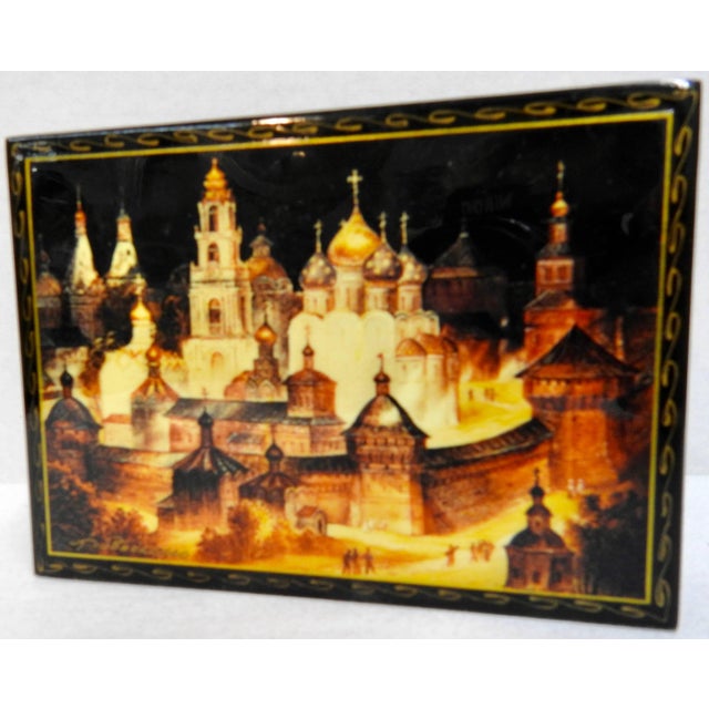 Elaborate architecture is displayed on this Russian black lacquer box with a vibrant red interior. It features the Kremlin...
