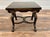 A striking pair of low decorative side tables featuring black lacquered finishes with hand-painted gold floral and foliate...
